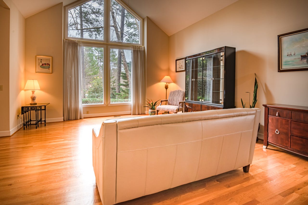 services-01 Inviting living room featuring large windows, modern decor, and wooden flooring, perfect for relaxation.
